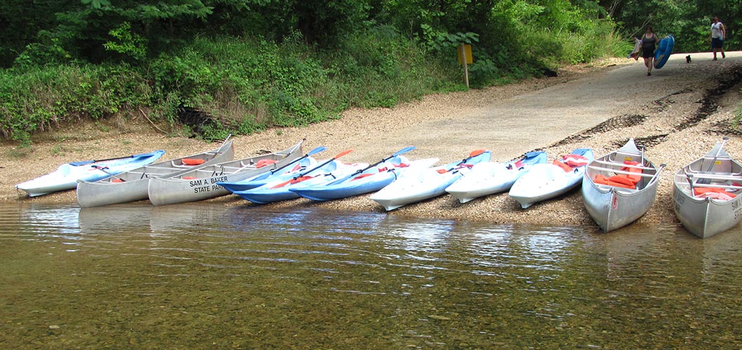 Multiple canoes lined up along the water line